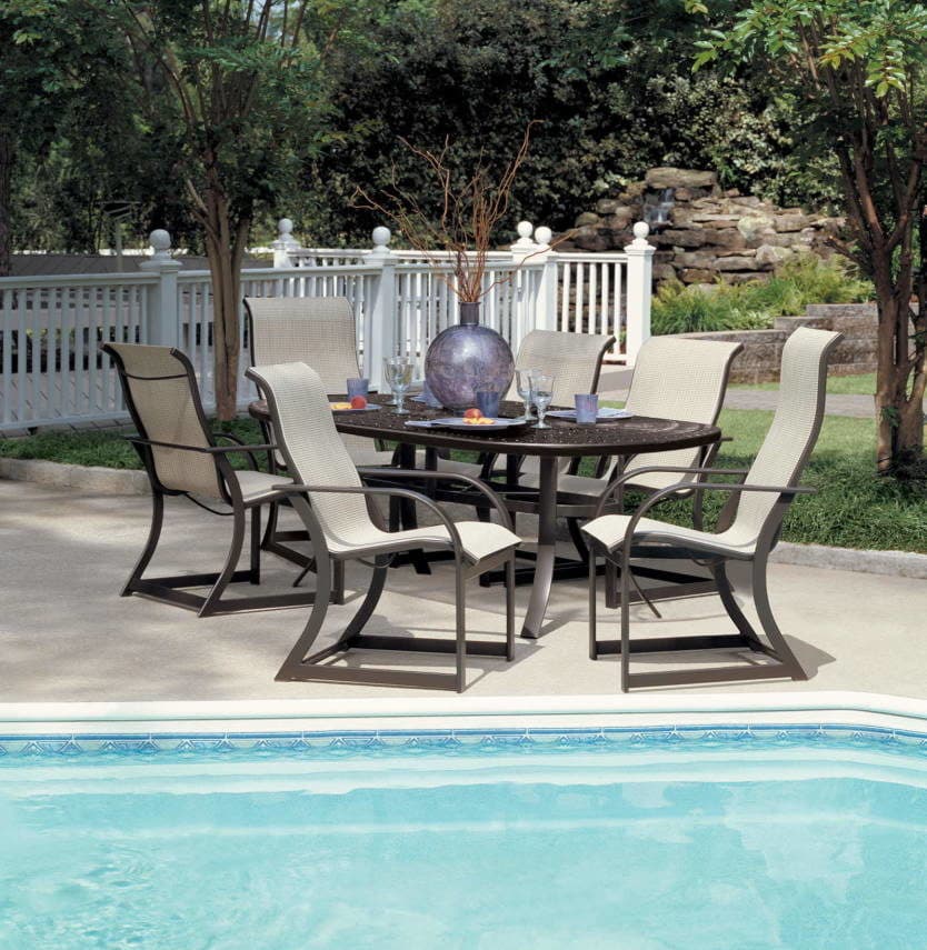 Sling dining chairs around a table on a poolside patio